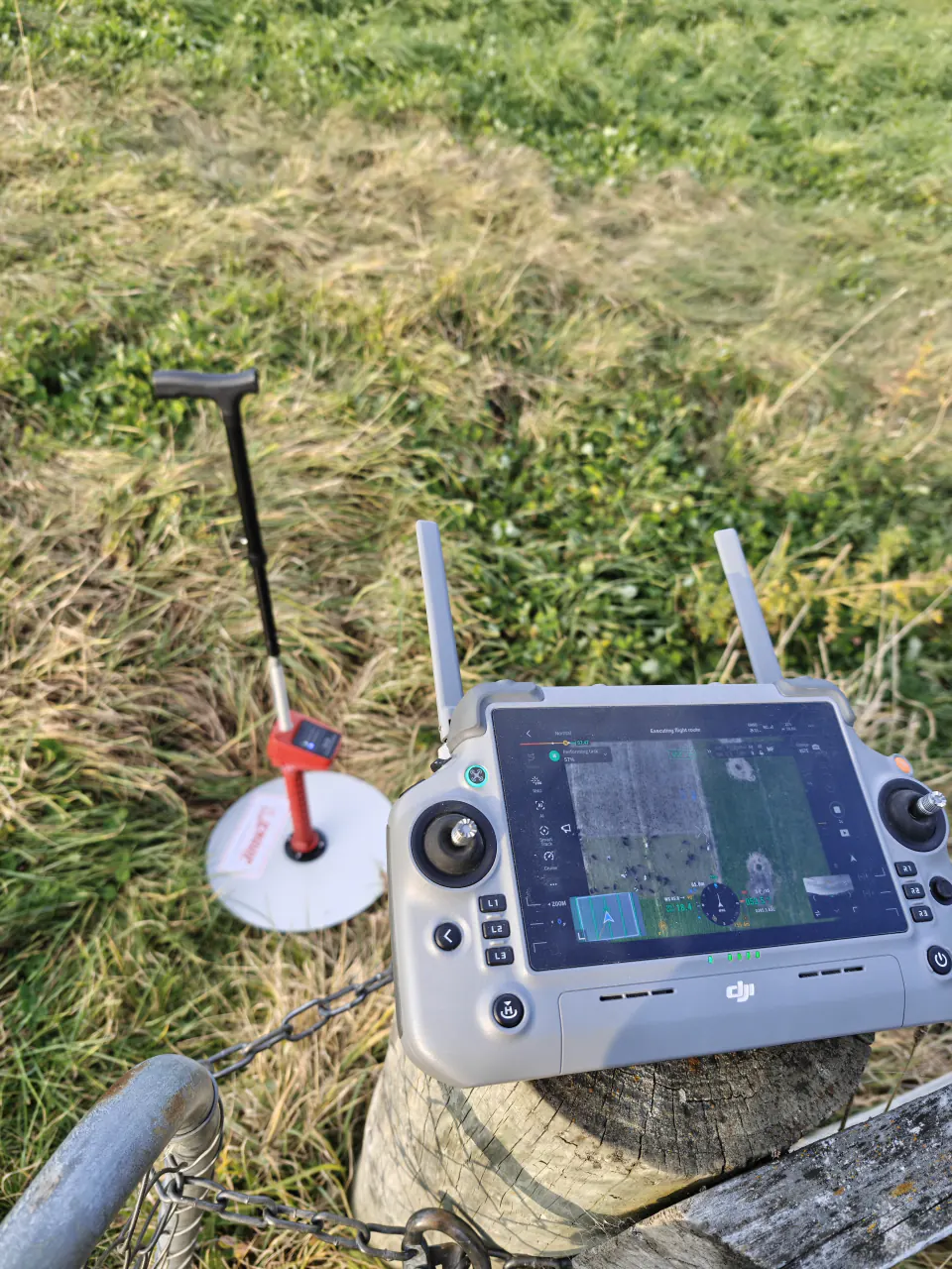 Drone controller beside a ground reference in a New Zealand pasture